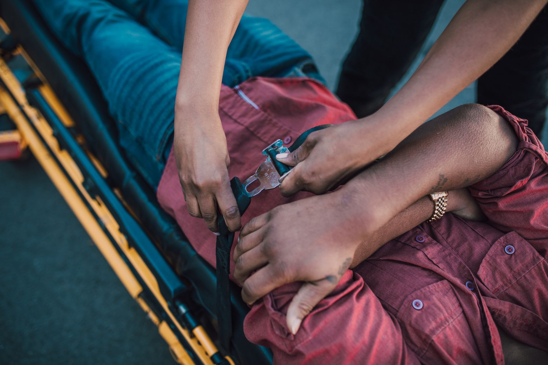 Paramedic securing an injured person onto a stretcher while providing emergency care.